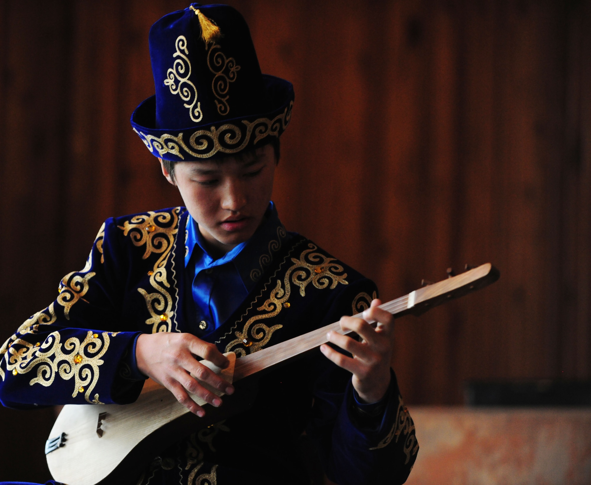 Kyrgyz students plays the Komuz, a local traditional instrument, for the Washington Redskins Cheerleaders at the Abdraev Musical Boarding School in Bishkek, Kyrgyzstan, Jan. 27, 2010. The cheerleaders are on tour sponsored by the Armed Forces Entertainment. The Transit Center at Manas is their first stop in a two-week long tour where they will perform for Airmen, Soldiers, Sailors and Marines deployed overseas. (U.S. Air Force photo/Senior Airman Nichelle Anderson/Released)
