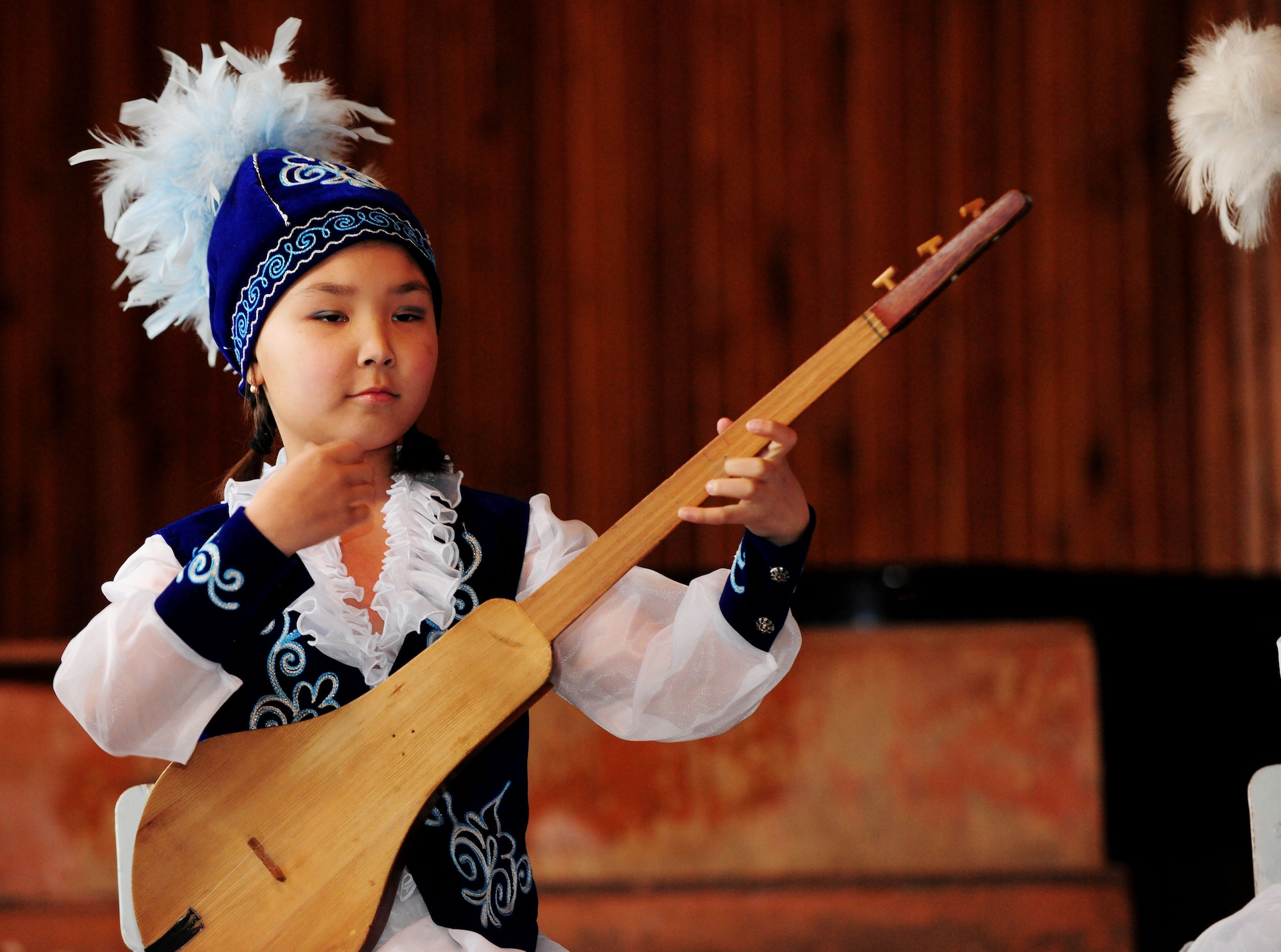 A young girl plays the Komuz, a Kyrgyz traditional instrument, for the Washington Redskins cheerleaders at the Abdraev Musical Boarding School in Bishkek, Kyrgyzstan, Jan. 27, 2010. The Cheerleaders are on tour sponsored by the Armed Forces Entertainment. The Transit Center at Manas is their first stop in a two-week long tour where they will perform for Airmen, Soldiers, Sailors and Marines deployed overseas. (U.S. Air Force photo/Senior Airman Nichelle Anderson/Released)