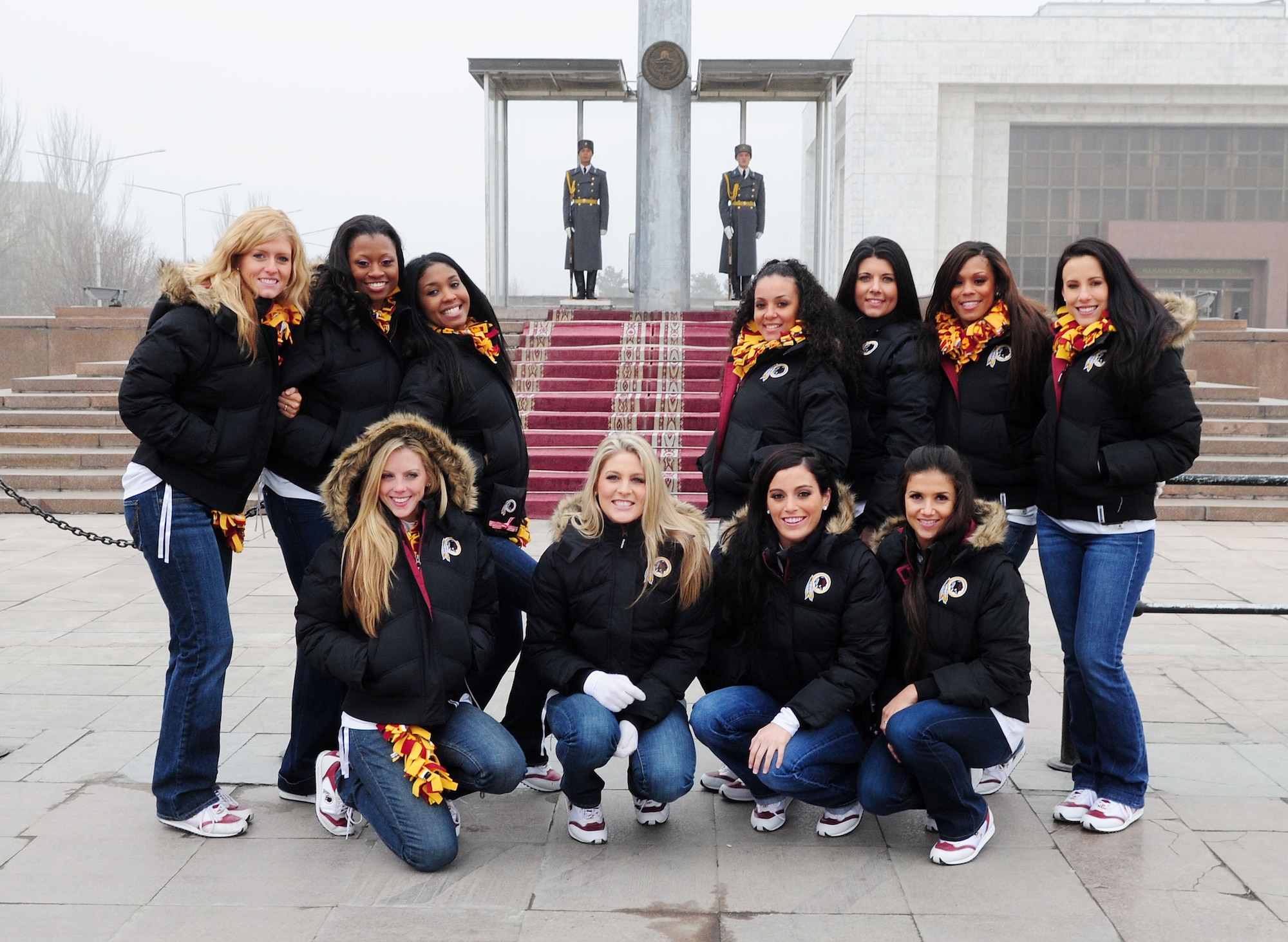 The Washington Redskins cheerleaders pose for a photograph in front of the guards during a history and cultural tour of downtown Bishkek, Kyrgyzstan, Jan. 27, 2010. Similar to the changing of the guard at the Tomb of the Unknown Soldier in Arlington, Va., guards stand to protect the Kygryz flag 24 hours a day. The Cheerleaders are on a tour sponsored by Armed Forces Entertainment. The Transit Center at Manas is their first stop in a two-week long tour where they will perform for Airmen, Soldiers, Sailors and Marines deployed overseas. (U.S. Air Force photo/Senior Airman Nichelle Anderson/Released