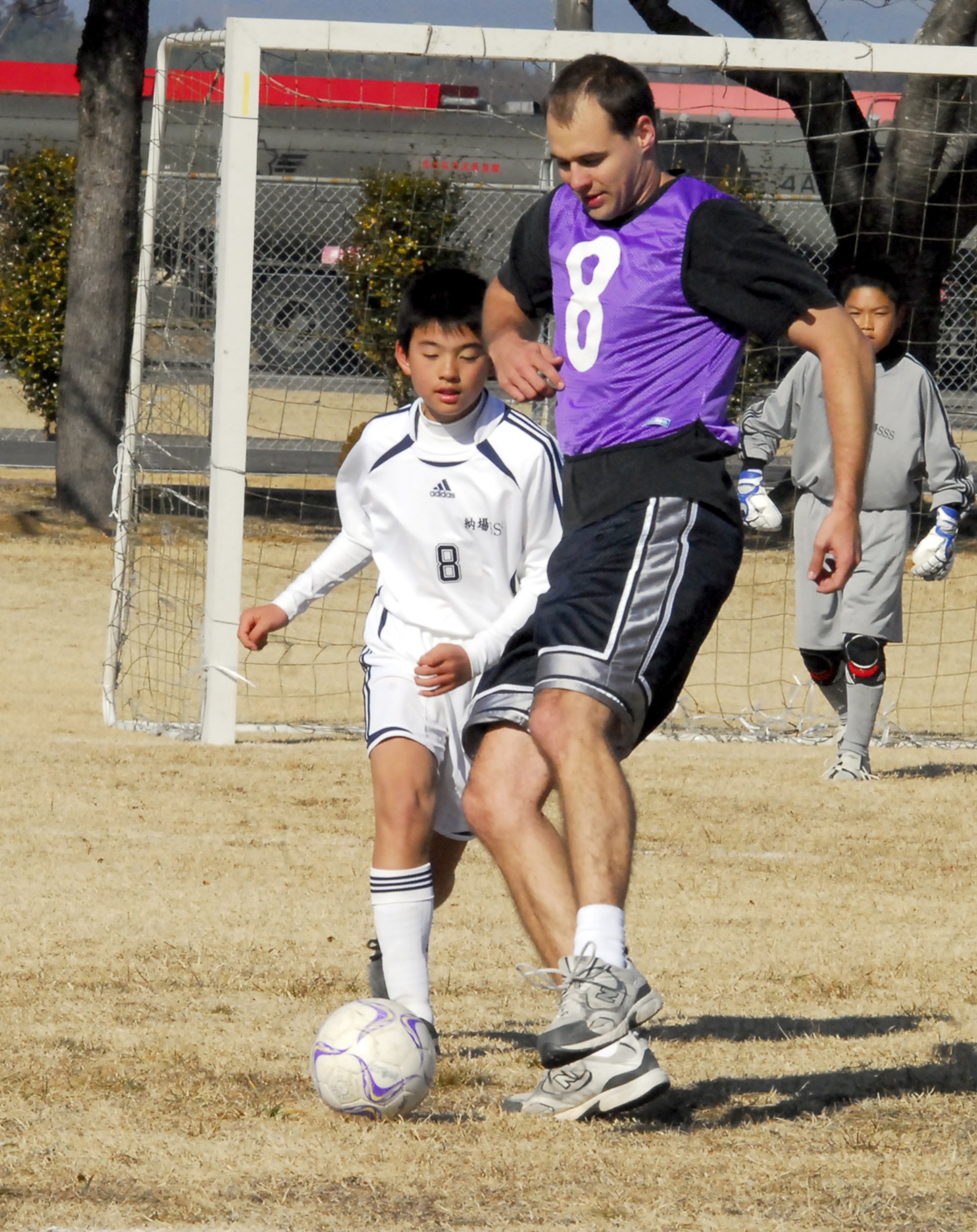 Capt. Darin Elgersma, a pilot in the 67th Fighter Squadron, plays soccer against a local children's club team Jan. 30 at Hyakuri Air Base, about 70 miles north of Tokyo. Soccer and basketball games were the focus of the morning, as teams from the surrounding community came to the base to play against and spend time with American Airmen. Captain Elgersma and almost 100 other Kadena Airmen are currently operating from Hyakuri as part of an aviation training relocation. (U.S. Air Force photo / 1st Lt. Bryan Bouchard)