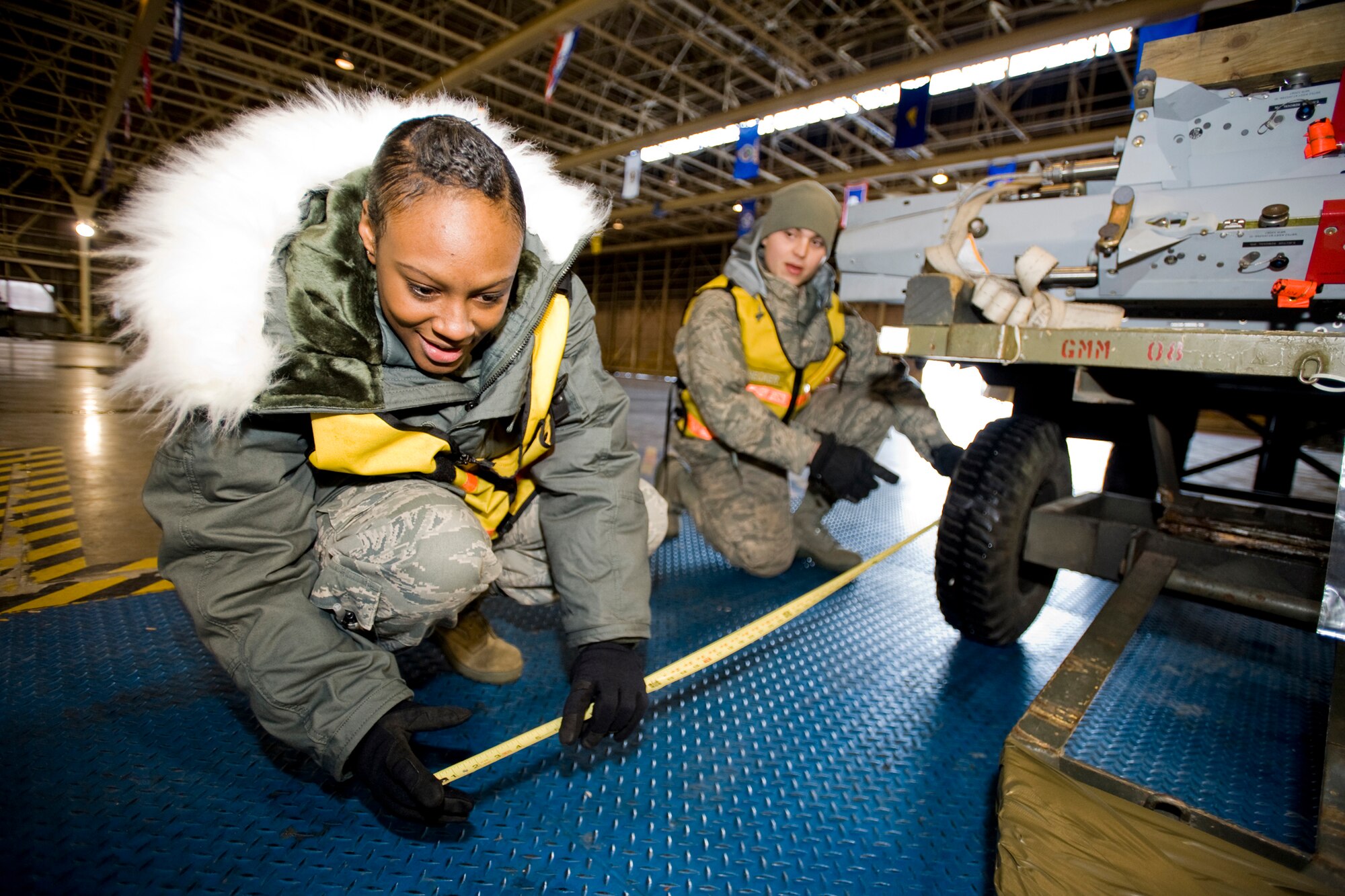 MISAWA AIR BASE, Japan -- Airman 1st Class Adreanna Jackson, 35th Logistics Readiness Squadron travel management apprentice, and Airman 1st Class Christopher Caldwell, 35th Maintenance Squadron jet-engine mechanic, measure for center balance on a weapons-pylon trailer during an operational readiness exercise Jan. 30 in Hangar 949. As in-checkers for the 35th Logistics Readiness Squadron cargo deployment function, they track the dimensions and weight of cargo prior to loading on the aircraft. (U.S. Air Force photo/Senior Airman Jamal D. Sutter)