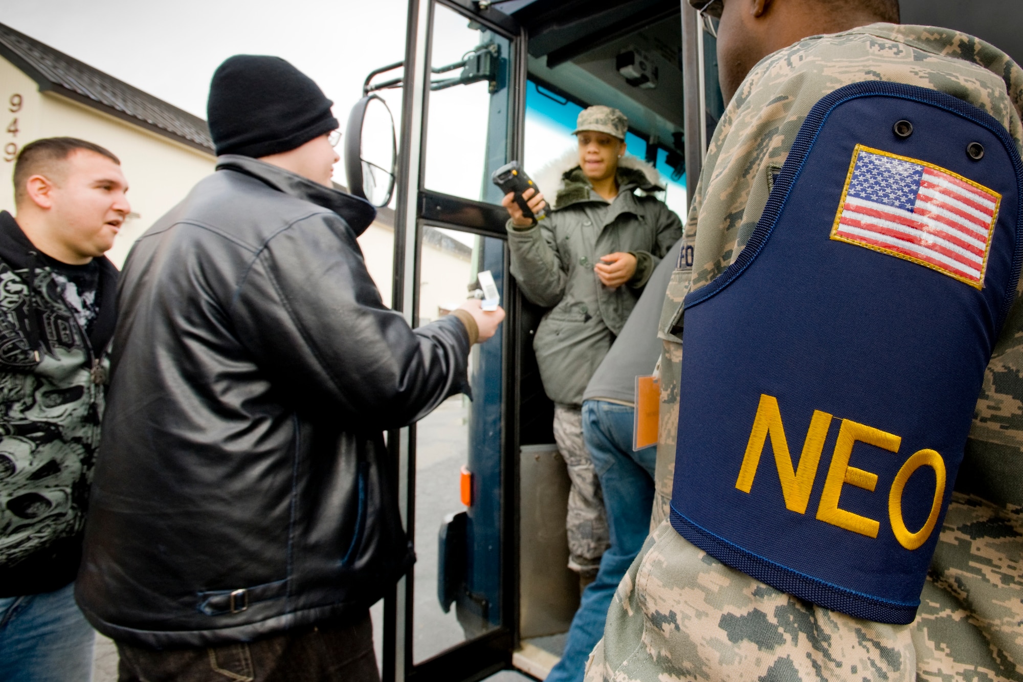 MISAWA AIR BASE, Japan -- As Staff Sgt. Larry Banks, 35th Force Support Squadron NCO in charge of formal training, escorts personnel, Staff Sgt. Shantelle Evans, 35th Aerospace Medical Squadron health care management technician, checks passports during the noncombatant evacuation operations portion of an operational readiness exercise Jan. 28 outside of Hangar 949. The exercise trained the NEO team on what to expect in the event that Misawa is called upon as a safe haven. (U.S. Air Force photo/Senior Airman Jamal D. Sutter)