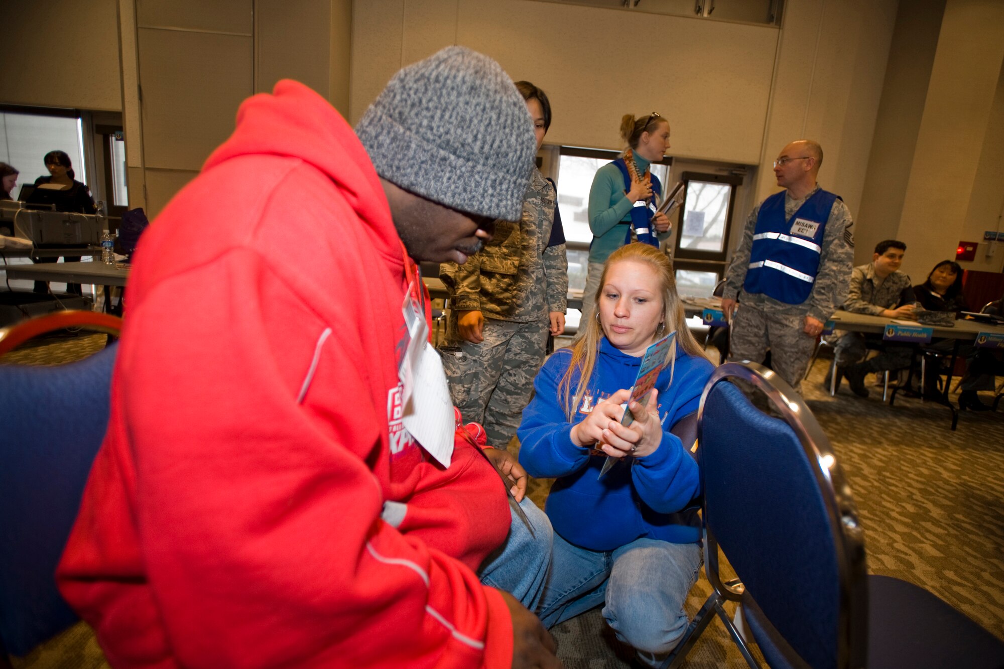 MISAWA AIR BASE, Japan -- Andrea Slayton, 35th Fighter Wing staff agencies administrative assistant, uses a card of symbols to communicate with Staff Sgt. Clinton Myers, 35th Medical Support Squadron information systems craftsman, while running noncombatant evacuation operations during an operational readiness exercise Jan. 28 at the Mokuteki ballroom. Sergeant Myers played the role of a hearing-impaired evacuee. (U.S. Air Force photo/Senior Airman Jamal D. Sutter)