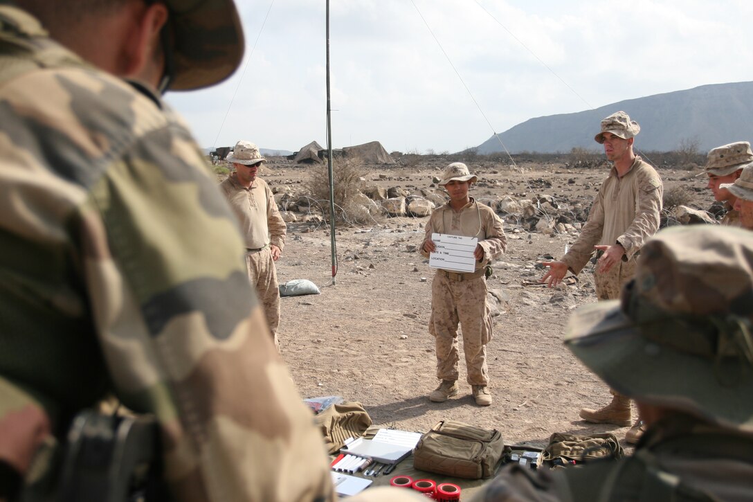 Private Roel Garcia, a rifleman from Freer, Texas (middle), and Cpl. Ian Cole, a rifleman from Orange Park, Fla., show members of the French Foreign Legion the materials that Marines use for tactical site exploitation here Jan. 30. Cole, Garcia, and other Marines with Company E, Battalion Landing Team 2/4, 11th Marine Expeditionary Unit, have been conducting live-fire exercises, patrols and bilateral training with French forces since Jan. 25.