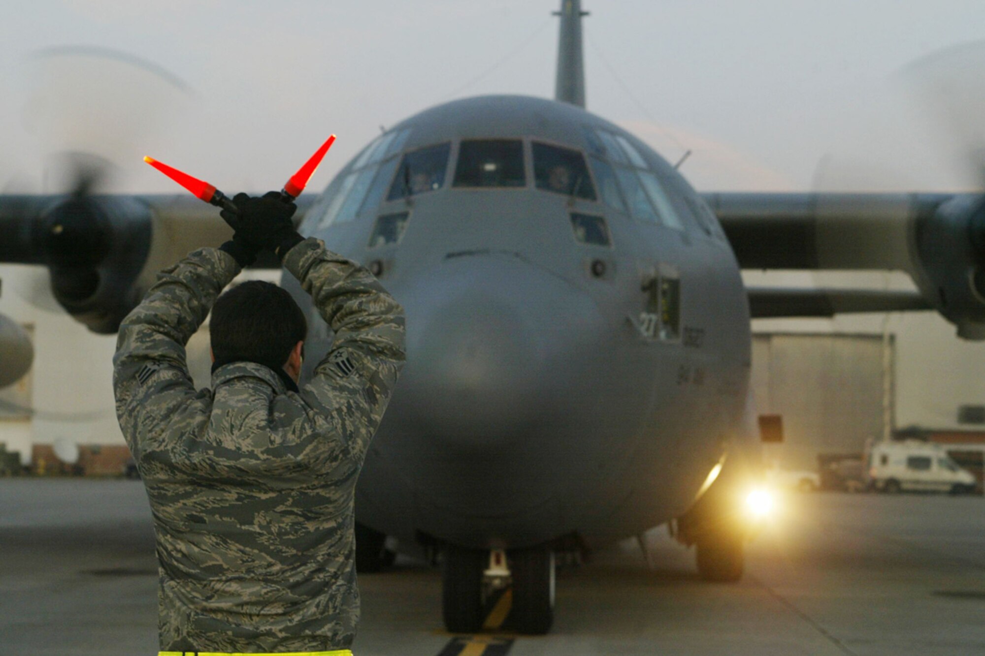 A crew chief guides a C-130H aircraft carrying returning 94th Aeromedical Evacuation Squadron members and equipment Jan. 31. The crew provided medical care to injured Haitians in support of Operation Unified Response for nearly two weeks. (U.S. Air Force photo/Don Peek)