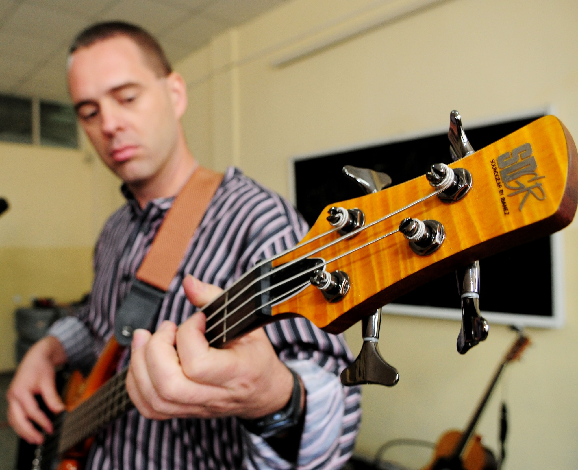 U.S. Air Force Master Sgt. Eric Sullivan, vocalist, bass, and cajon player, tunes his guitar before performing at the Police Academy in Bishkek, Kyrgyzstan, Jan. 28, 2010. “Celtic Aire,” the U.S. Air Forces Central Public Affairs band, is scheduled to play at several bases in the AOR to entertain deployed Airman, Soldiers, Sailors and Marines. While in Kyrgyzstan, the band received a unique opportunity to perform for the local community. (U.S. Air Force photo/Senior Airman Nichelle Anderson/released)