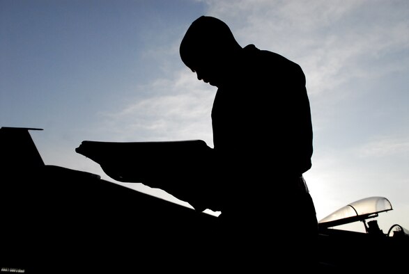 Airman 1st Class Eldridge Rouse, a crew chief from the 67th Aircraft Maintenance Unit, checks forms before the morning's first "go" Feb. 1 at Hyakuri Air Base, about 70 miles north of Tokyo. Airmen from the 18th Wing are operating from the Japanese base as part of an aviation training relocation. (U.S. Air Force photo / 1st Lt. Bryan Bouchard)