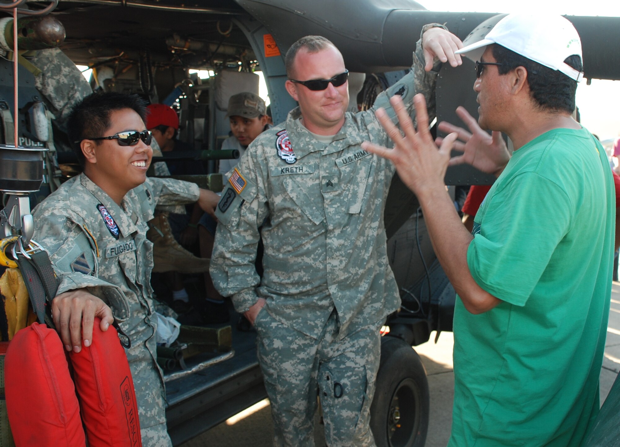 U.S. Army Specialist Bryan Fulgado and Sgt. Daniel Kreth, HH-60 Black Hawk crew members, talk with a Salvadoran spectator at the helicopter's static display during the 2010 Ilopango Air Show in Ilopango, El Salvador, Jan. 30. The U.S. military supported the air show with an HH-60 Black Hawk and a CH-47 Chinook from Joint Task Force-Bravo, Soto Cano Air Base, Honduras, along with two U.S. Air Force B-1B Lancers from the 7th Bomb Wing, Dyess Air Force Base, Texas. (U.S. Air Force photo by 1st Lt. Jen Richard) 