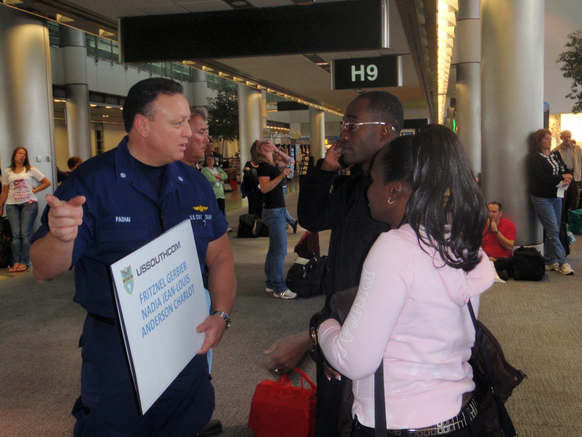 Cmdr. Jeff Pashai; U.S. Southern Command Coast Guard TCA liaison; greets two Haitian coast guard members at the Miami International Airport; Jan. 23. The Haitian military members are part of the International Military Exchange Training program and have spent the past six to eight months studying in the U.S. With the help of multiple U.S. military service; seven students found the means to travel back to Haiti and reunite with family members. (U.S. Air Force photo by Senior Airman Danielle Grannan)