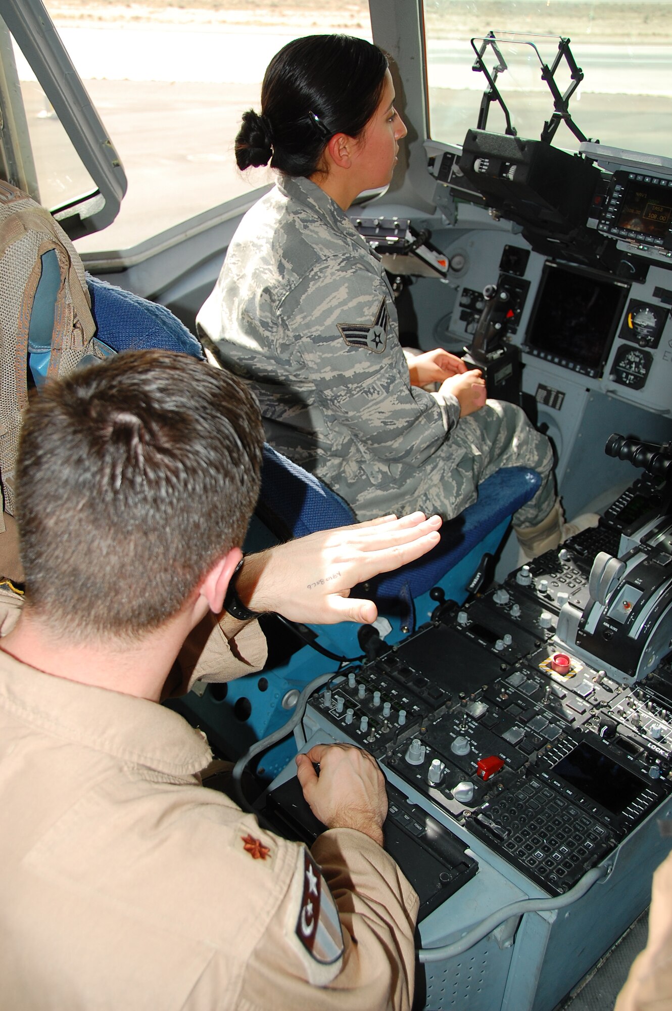 Maj. Ryan Vander Veen, 817th Expeditionary Airlift Squadron C-17 pilot, shows Senior Airman Xanadu Moldenhauer, 386th Expeditionary Operations Support Squadron, the cockpit of a C-17 during the Quarry Open House Jan. 30, 2010 at an air base in Southwest Asia. (U.S. Air Force photo by Staff Sgt. Lindsey Maurice/Released)