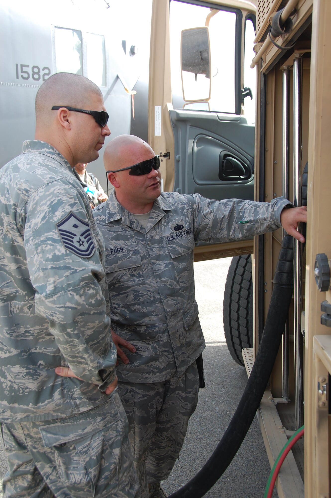 U.S. Air Force Tech. Sgt. Joseph Pugh, 386th Expeditionary Logistics Readiness Squadron petroleum, oil and lubricants distribution supervisor, shows one of the unit's fuel trucks to Master Sgt. Carlos Chavez, 386th Expeditionary Communications Squadron first sergeant, during the Quarry Open House Jan. 30, 2010 at an air base in Southwest Asia. (U.S. Air Force photo by Staff Sgt. Lindsey Maurice/Released)