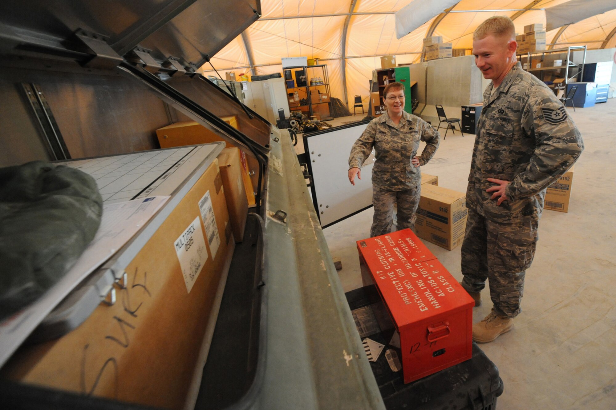 Master Sgt. Lorna Gomez and Tech. Sgt. Danny Smith, 379th Expeditionary Operations Support Squadron aircrew flight equipment, discuss which training items to pack on a pallet at a non-disclosed Southwest Asia location, Jan. 25, 2010. The equipment will be sent to Afghanistan for International Security Assistance Force Aircrew Flight Equipment trainers to teach Afghani instuctors to train their airmen.  (U.S. Air Force photo byTech. Sgt. Michelle Larche)[RELEASE]