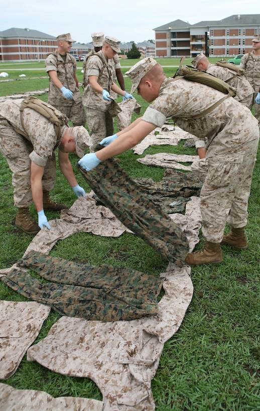 Students attending Marine Combat Training prepare utilities to aid technicians with preventive medicine unit, 2nd Medical Battalion, Combat Logistics Regiment 25, 2nd Marine Logistics Group, who were spraying both sides of the uniforms during a PMU assignment aboard Camp Geiger, N.C., July 1, 2010.  The spray benefits Marines who are training at MCT by protecting them against insect bites and stings.