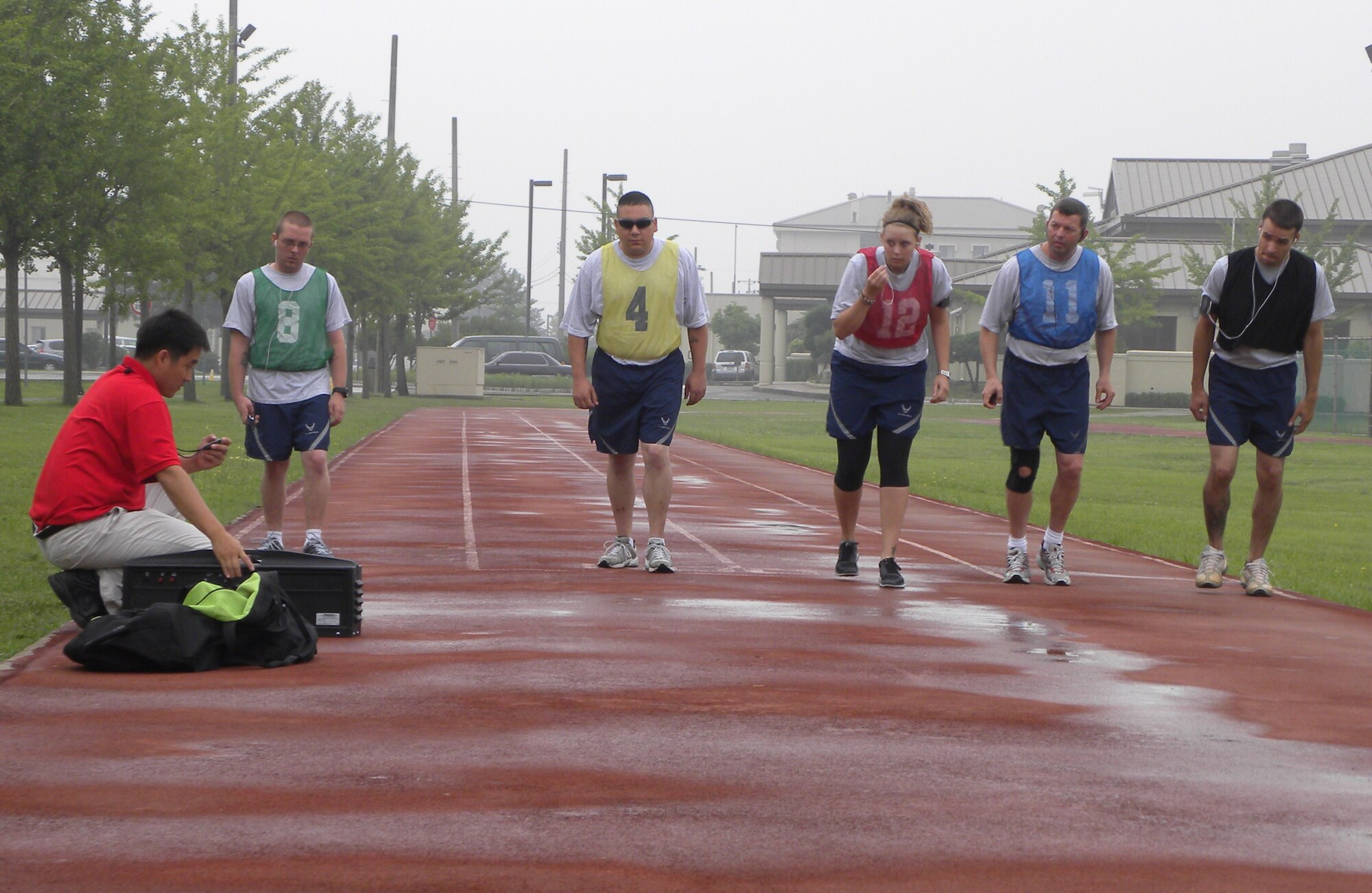 KUNSAN AIR BASE, Republic of Korea -- Hong Sin-chae, 8th Force Support Squadron Fitness Assessment Cell test administrator, starts the run portion of the Air Force physical training test July 1 for the first five Airmen to test after the new PT test scoring standards took effect. The run now counts for 60 points out of a possible 100, the abdominal circumference now counts for 20 points and the pushups and sit-ups remained at 10 points each. Airmen must also meet minimum standards in each component. (U.S. Air Force photo/Staff Sgt. Amanda Savannah) 