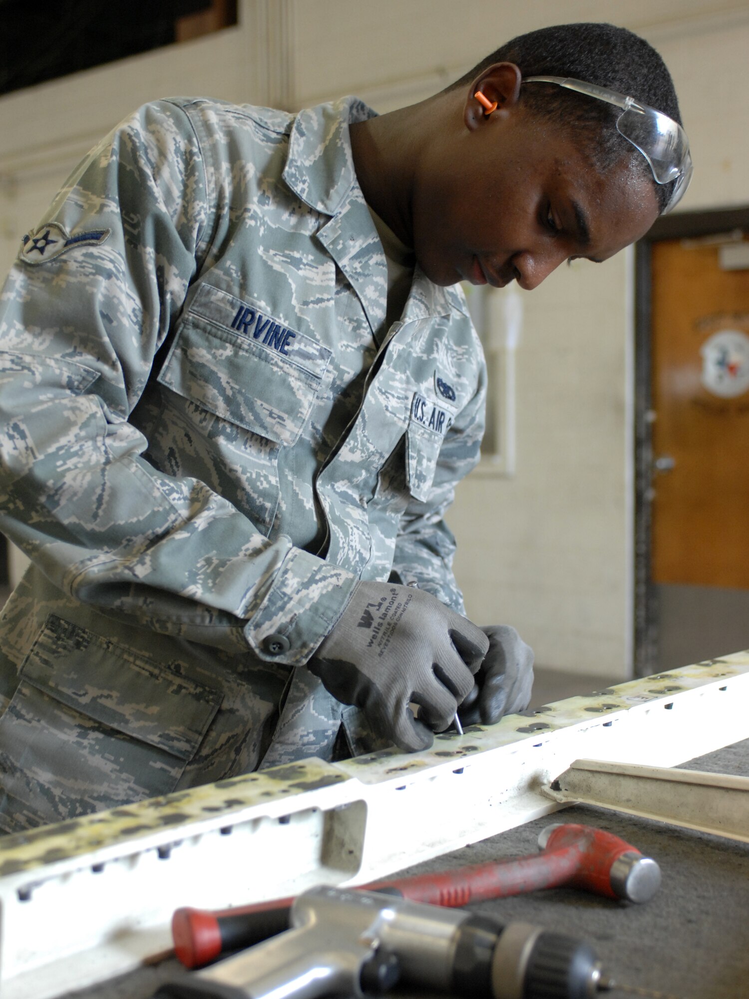 DYESS AIR FORCE BASE, Texas – Airman Craig Irvine, 7th Equipment Maintenance Squadron Aircraft Structural Maintenance Apprentice, removes and replaces pull-through rivets on a lower spring panel for a B-1 Bomber June 30 at the aircraft structural maintenance shop here.  Maintainers repair aircraft in preparation for deployments and training in support of Overseas Contingency Operations.  (U.S. Air Force photo/Senior Airman Jenifer H. Calhoun)