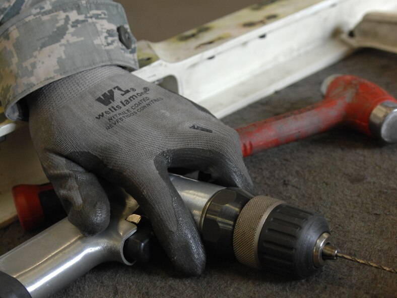 DYESS AIR FORCE BASE, Texas – Airman Craig Irvine, 7th Equipment Maintenance Squadron Aircraft Structural Maintenance Apprentice, removes and replaces pull-through rivets on a lower spring panel for a B-1 Bomber June 30 at the aircraft structural maintenance shop here.  Maintainers repair aircraft in preparation for deployments and training in support of Overseas Contingency Operations.  (U.S. Air Force photo/Senior Airman Jenifer H. Calhoun)
