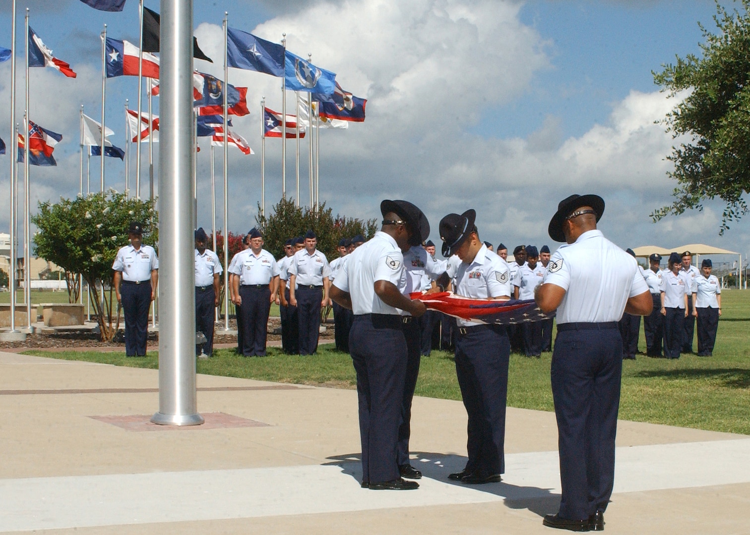 Airmen from the Senior NCO Professional Development Seminar fold the flag during retreat at the 37th Training Wing headquarters building flagpole June 25. The flag was presented to Marie Campbell, wife of Sgt. Millard Dee Campbell, one of 19 Airmen killed during a terrorist attack at Khobar Towers in Dhahran, Saudi Arabia. (U.S. Air Force photo/Sid Luna)