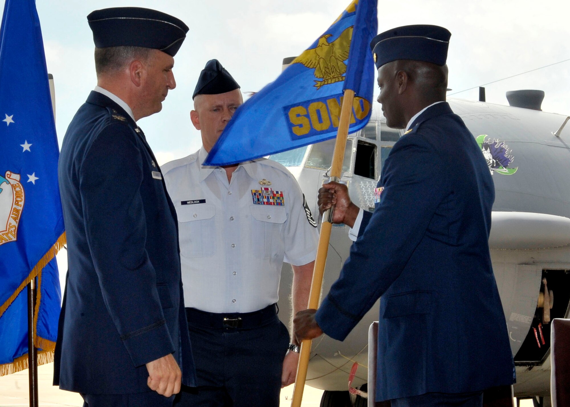 U.S. Air Force Maj. Deedrick Reese (right), 27th Special Operations Maintenance Operations Squadron commander, presents the squadron guidon to U.S. Air Force Master Sgt. Victor Medlock (center), 27th Special Operations Maintenance Operations Squadron, after assuming command by U.S. Air Force Col. Mark LaRose (left), 27th Special Operations Maintenance Group commander, at Cannon Air Force Base, N.M., July 1, 2010.  U.S. Air Force Maj. Ryan White served as the 27th SOMOS commander since July 2008. (U.S. Air Force photo by Staff Sgt. Heather R. Redman)
