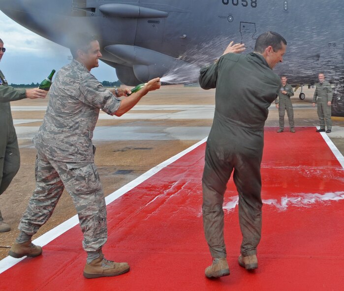 BARKSDALE AIR FORCE BASE, La. -- Col. Steven Basham, 2d Bomb Wing commander, drenches Col. Gerald Hounchell, 2d Bomb Wing vice commander, with a bottle of champagne after his fini-flight June 30. Colonel Hounchell has more than 4,200 flight hours during his career. (U.S. Air Force photo by Senior Airman Alexandra M. Boutte) (RELEASED)