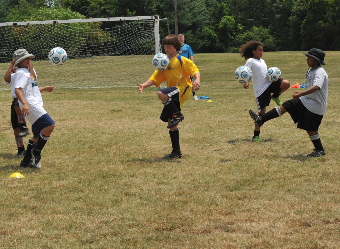 Team Andrews Youth Center children perform a juggling drill June 25 at the Washington Field, near The Courses at Andrews June 25. Sponsored by Challenger Sports, the week-long camp ran from June 21 through June 25, and introduced the children to basic fundamentals of soccer including dribbling, passing, ball control and team camaraderie. (U.S. Air Force photo/ Bobby Jones)