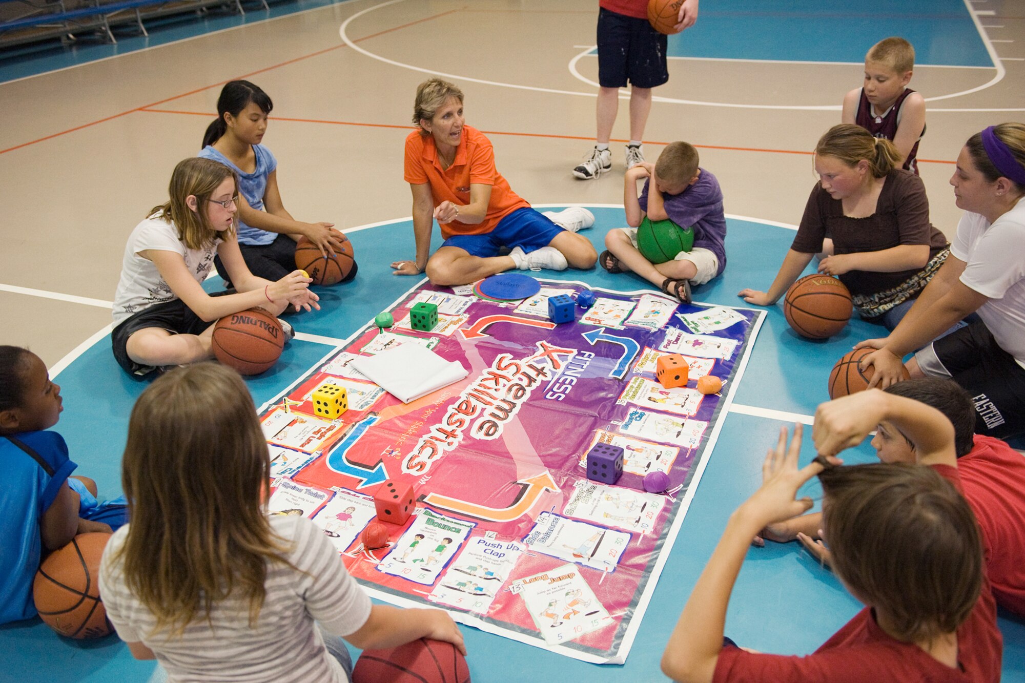 Sandy Slade explains one of the activities she uses to get kids intersted in fitness to participants during the clinic she presented June 29 at the Youth Activities Center.. (U.S. Air Force Photo/Beau Wade)