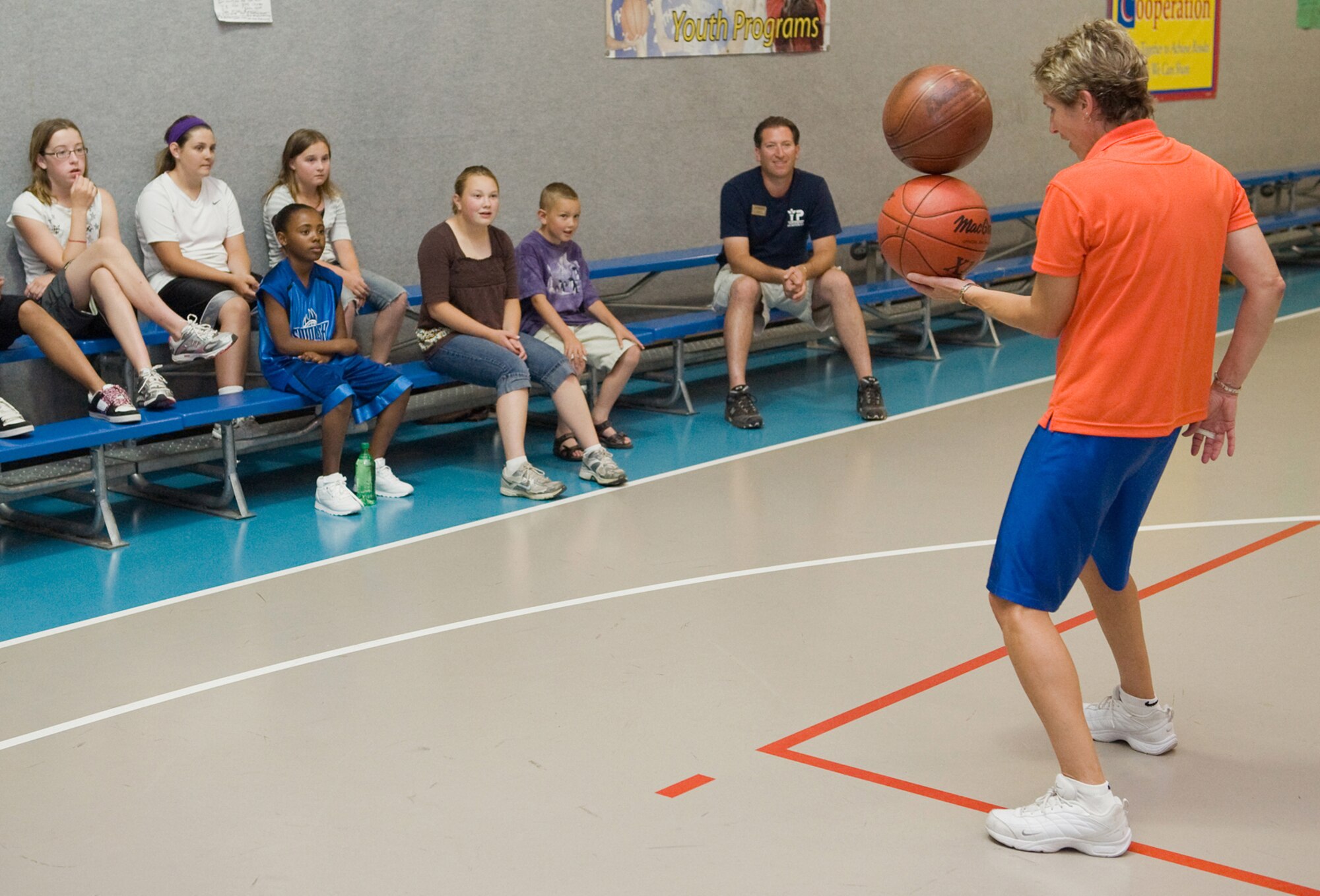 Sandy Slade caught the immediate attenntion of the youth signed up for her clinic when she spun one basketball on top of another June 29 at the Youth Activities Center Gym. (U.S. Air Force Photo/Beau Wade)