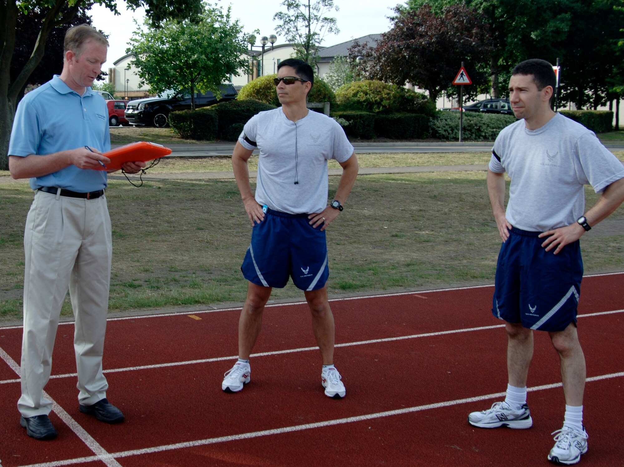 Rick Lyons, 48th Force Support Squadron Fitness Assessment Cell fitness testing technician, explains to Col. John Quintas, 48th Fighter Wing commander, and Maj. Doug Nocera, 48th Fighter Wing director of staff, the procedures for the 1.5-mile run component of the Air Force fitness test at the RAF Lakenheath running track July 1. Colonel Quintas, Major Nocera and 13 other Liberty warriors completed their semi-annual fitness tests on the first day of the implementation the test's new standards. Colonel Quintas and Major Nocera both scored in the "excellent" category. (U.S. Air Force photo/Capt. Alysia Harvey)