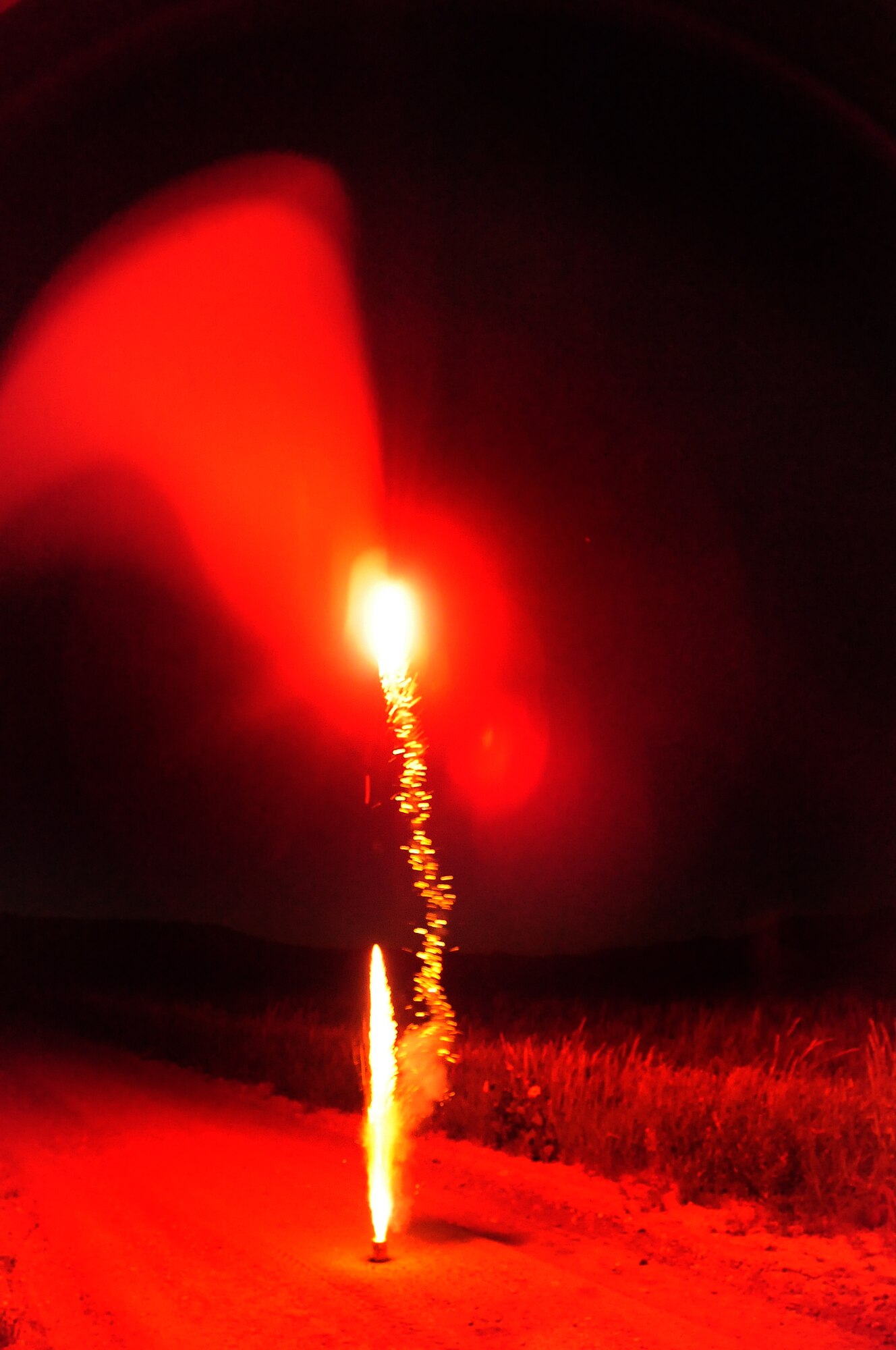 ELLSWORTH AIR FORCE BASE, S.D. -- Several red glowing fire balls erupt from a firework, Fairburn South Dakota, June 29.  Check state and local laws on the types of fireworks allowed before shooting off fireworks. (U.S. Air Force photo/Airman 1st Class Anthony Sanchelli)