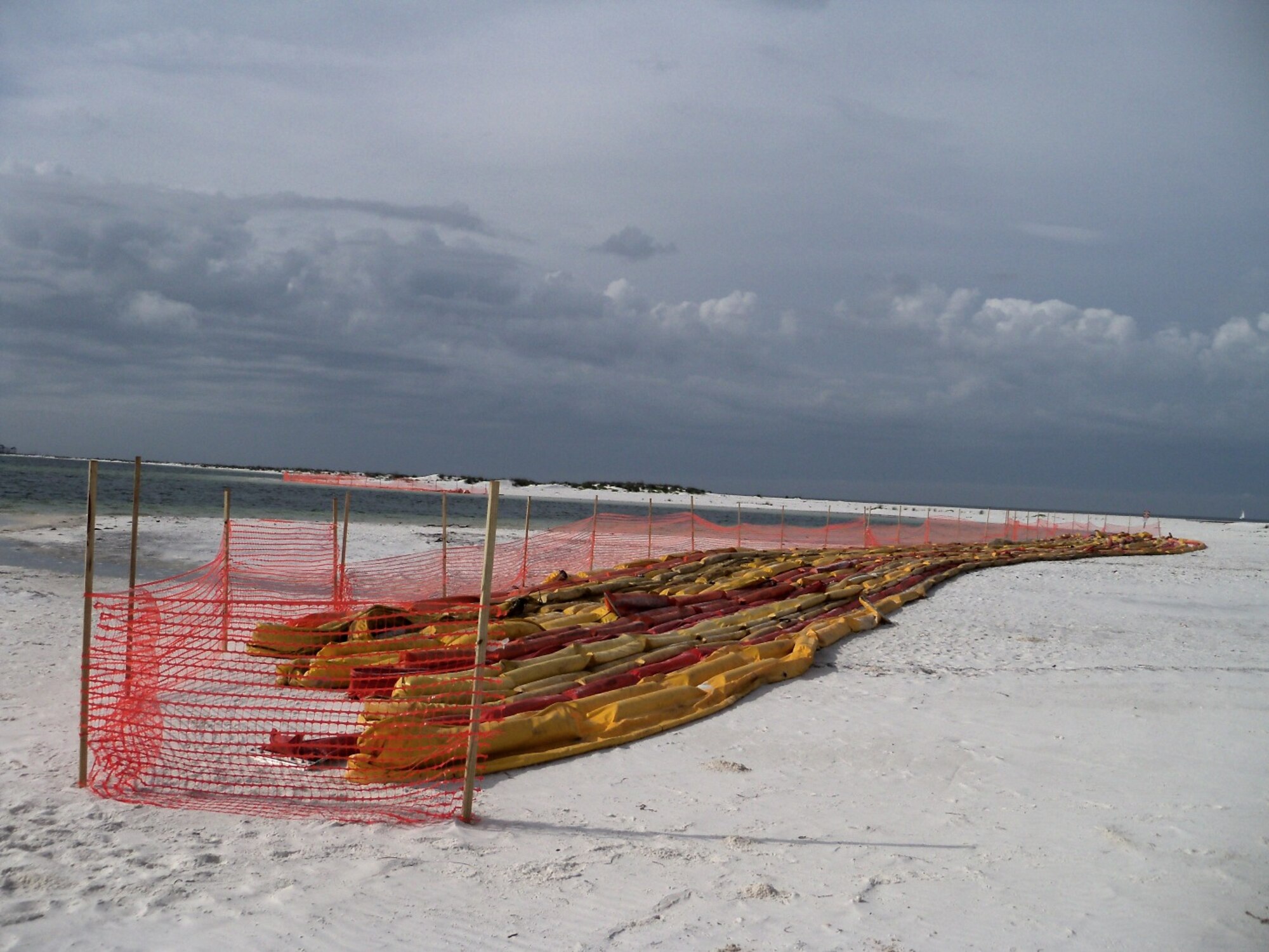 Oil containment booms lay along a beach on Tyndall July 1. The base has approximately 7,000 feet of boom, which form a barrier that skims oil and debris from the surface of the water.  The boom is foldable, lightweight and is made of a vinyl-coated polyester. Installed at Tyndall in early May, all boom placements are per the U.S. Coast Guard Sector Mobile Area Contingency Plan. (Courtesy photo)