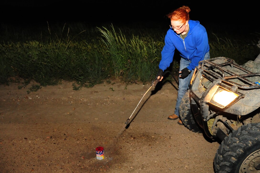 ELLSWORTH AIR FORCE BASE, S.D. -- 1st Lt. Amy Neeves, 28th Bomb Wing deputy chief of public affairs, sprays down a firework which failed to ignite, Fairburn South Dakota, June 29.  Always have a source of water handy in case of a dud or misfire. (U.S. Air Force photo/Airman 1st Class Anthony Sanchelli)