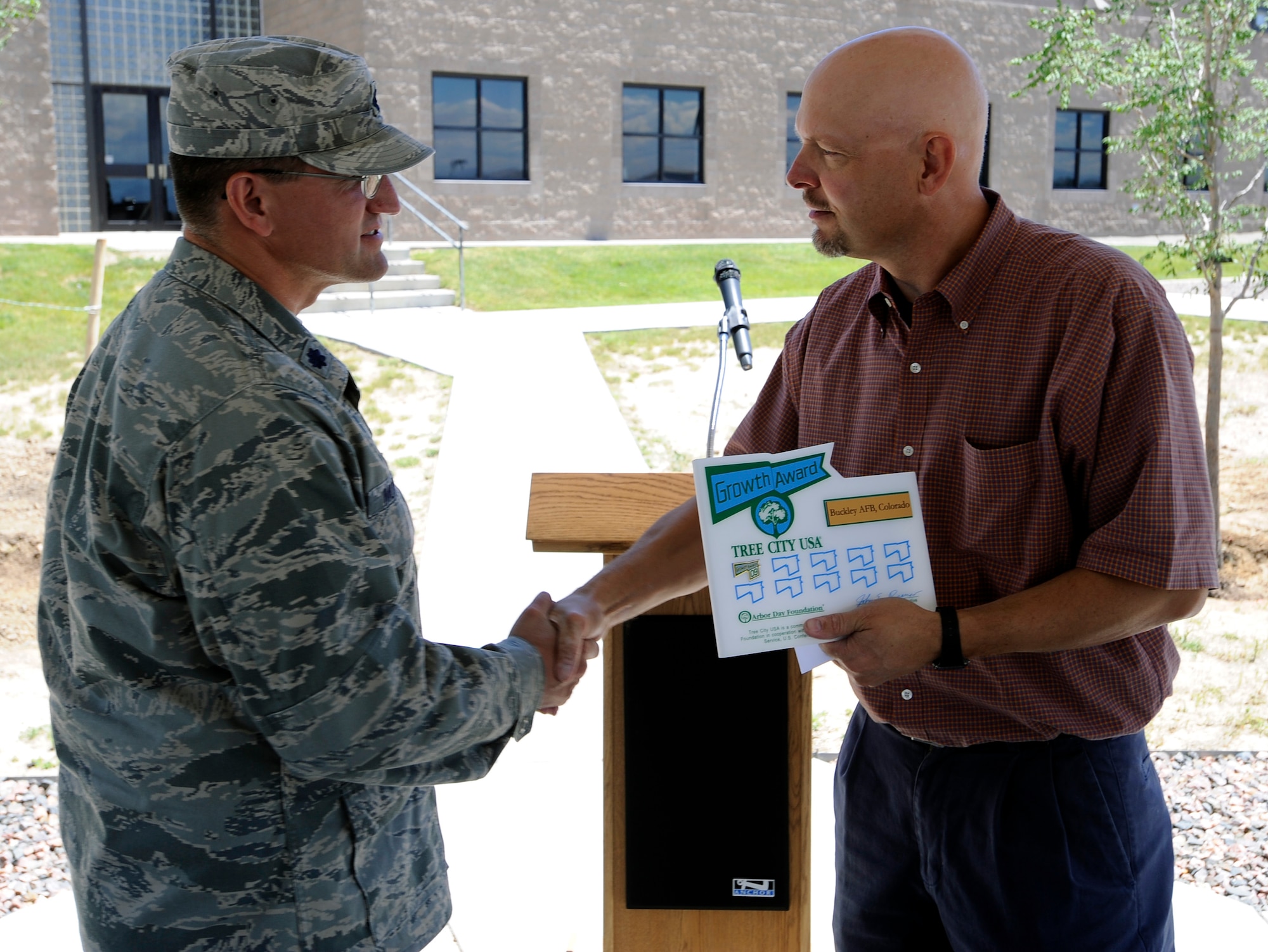 BUCKLEY AIR FORCE BASE, Colo. -- Keith Wood, a Colorado State Forester, presents Lt. Col. William Morrison, 460th Mission Support Group deputy commander, the Tree City USA award during the Arbor Day Celebration June 30. (U.S. Air Force photo by Staff Sgt. Dallas Edwards)