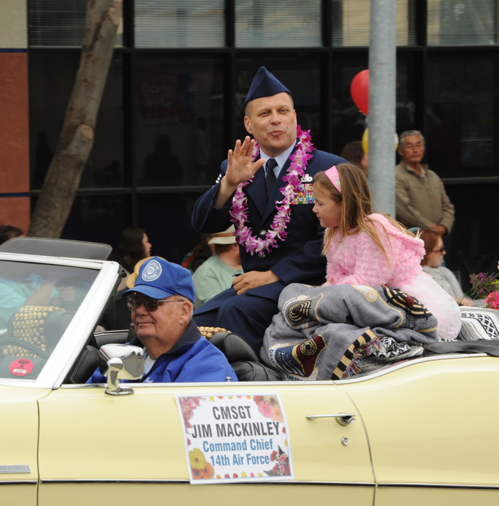 LOMPOC, Calif. --  Chief Master Sgt. Jim Mackinley, the 14th Air Force command chief, rides along with his daughter, Madison Mackinley, in the Flower Festival parade here Saturday, June 26, 2010. The Flower Festival is an annual event that is planned for the third week of June so that major crops of flowers will be in bloom. (U.S. Air Force Photo/Senior Airman Bryan Boyette)