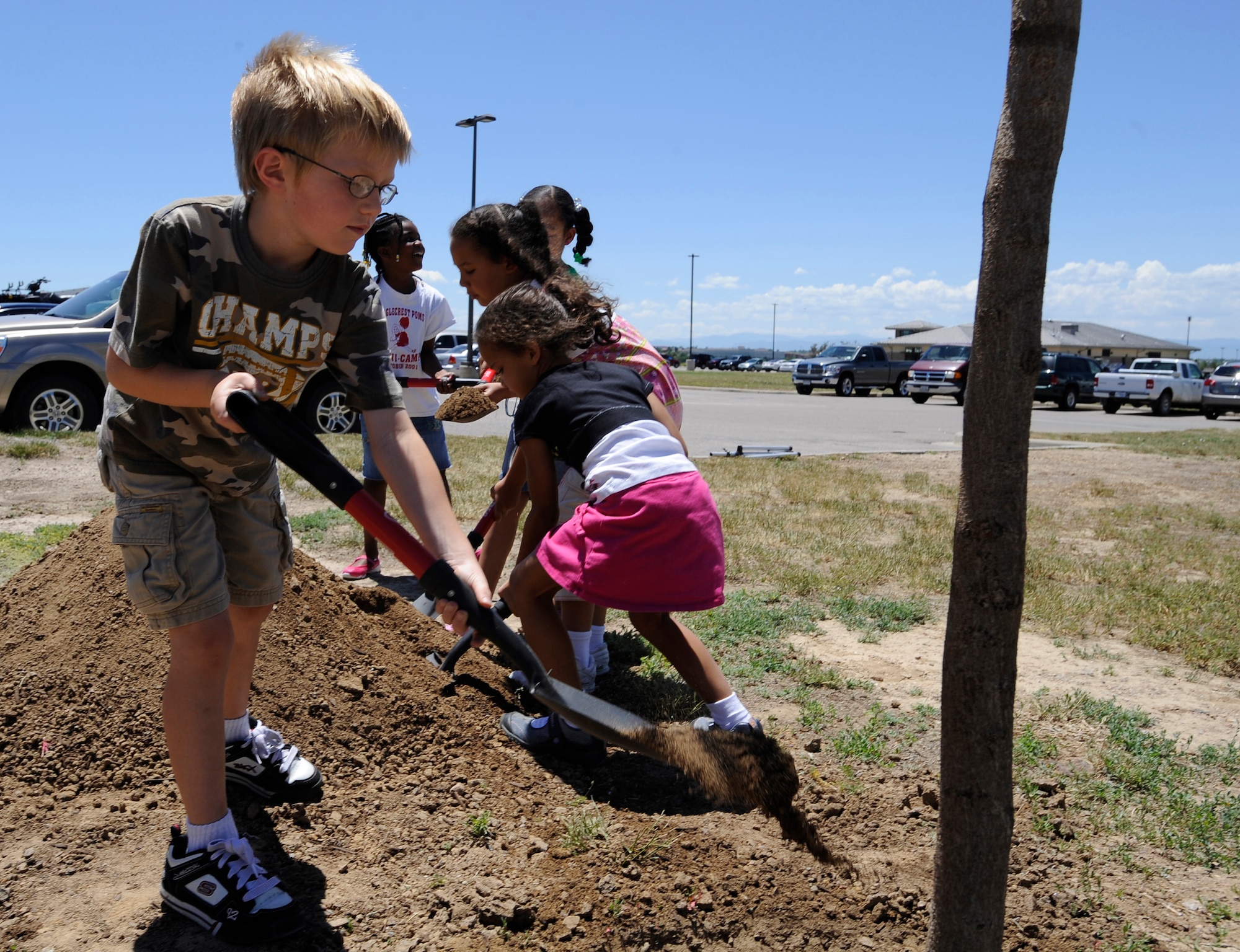 BUCKLEY AIR FORCE BASE, Colo. -- Six-year-old Conner Miller, a base dependent, places soil at the base of a newly planted tree during the Arbor Day celebration June 30. (U.S. Air Force photo by Staff Sgt. Dallas Edwards)