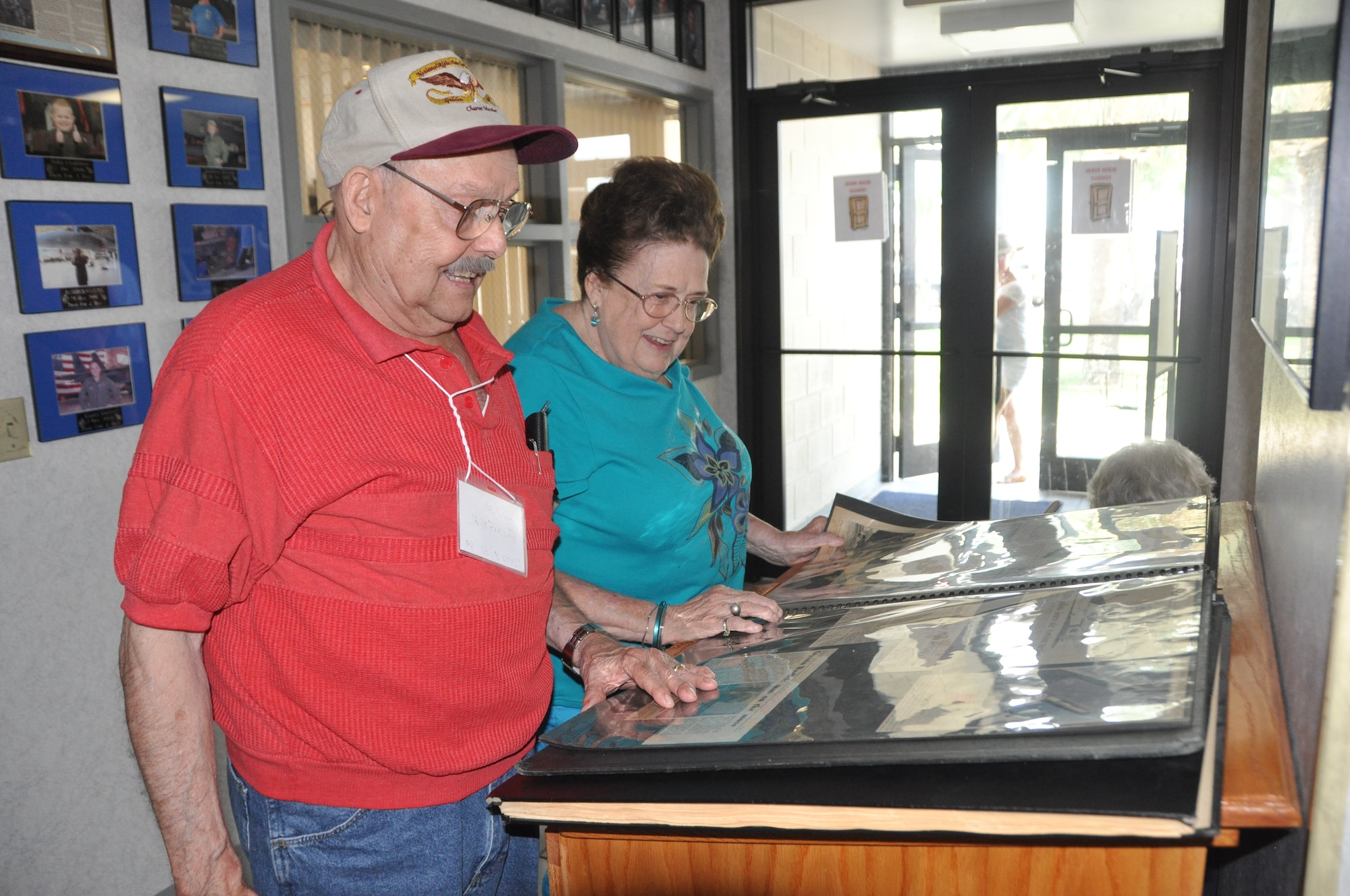 Jim Ginger, former 95th Fighter Squadron Bonehead, and his wife, Jeri, look through old photos and news clips from the times they spent in the squadron during the last 95th FS reunion at Tyndall.  (U.S. Air Force photo/Airman 1st Class Rachelle Elsea)
