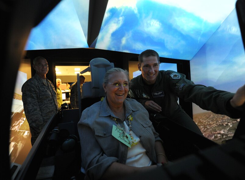 MOODY AIR FORCE BASE, Ga. -- Norma Holland, wife of Maj. Gen. William Holland, 9th Air Force commander, takes a flight in the A-10C Thunderbolt II simulator as Capt. Dustin Ireland, 74th Fighter Squadron weapons and tactics chief, assists her with the controls here June 29. Ms. Holland had the chance to dog-fight her husband during his during a portion of the simulated flight. (U.S. Air Force photo by Airman 1st Class Benjamin Wiseman/RELEASED)