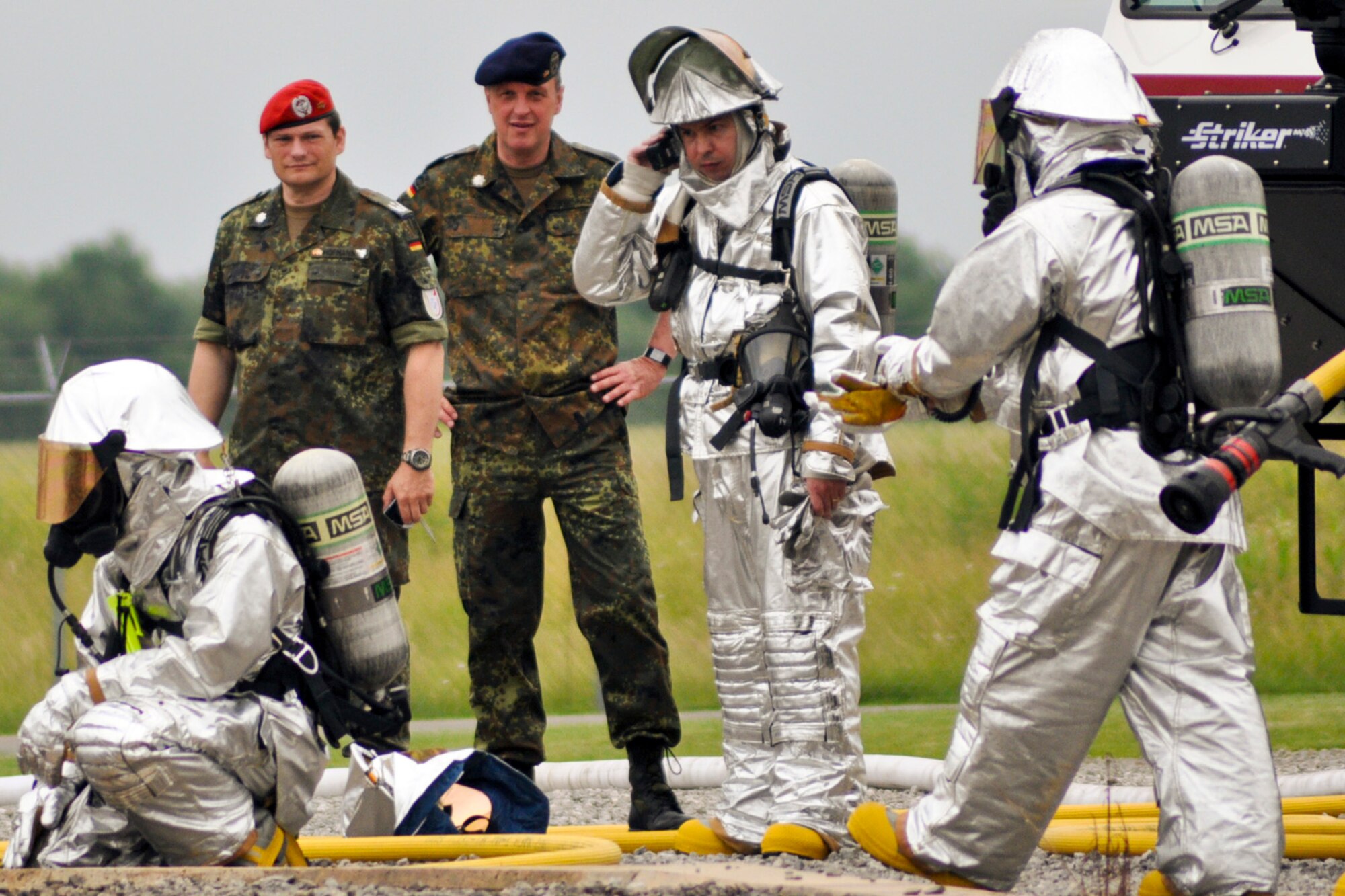 YOUNGSTOWN AIR RESERVE STATION, Ohio -- Members of the U.S. Air Force Reserve's 910th Civil Engineer Fire Department conduct a simulated aircraft fire demonstration for German reserve officers Lt. Col. Patrick Hofmann and Lt. Col. Stefan Bernreider at the wing?s fire pit June 17. The officers visited the Youngstown Air Reserve Station, June 12-26, as part of the Department of Defense Reserve Officers Exchange Program. The primary purpose of the exchange program is to provide National Guard and Reserve officers training associated with mobilization duties while enhancing their ability to work and communicate with the military individuals of the host nation. Reserve officers who participate in the exchange program receive valuable training, which they are able to share with their home units.  They gain an appreciation of allied Reserve forces, which facilitates an effective working relationship with those forces upon mobilization. The Office of the Assistant Secretary of Defense (Reserve Affairs) oversees this program since its inception in 1985. U.S. Air Force photo by Master Sgt. Bob Barko Jr. 