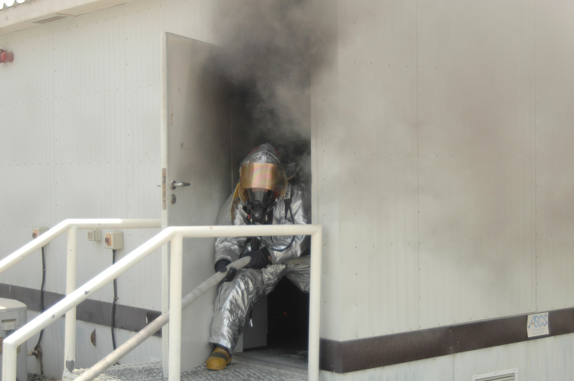 Airman 1st Class Dustin Stromme, 380th Expeditionary Civil Engineer Squadron fire fighter, drags a hose into a burning structure June 30 at a non-disclosed base in Southwest Asia. The fire fighters’ quick response minimized damage to the building. (U.S. Air Force photo/Staff Sgt. Jeremy Larlee)