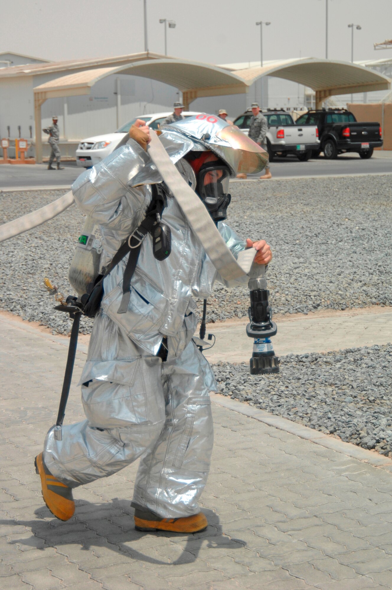 Staff Sgt. David Webster, 380th Expeditionary Civil Engineer Squadron fire fighter, readies a hose to combat a fire June 30 at a non-disclosed base in Southwest Asia. The fire fighters’ quick response minimized damage to the building. (U.S. Air Force photo/Staff Sgt. Jeremy Larlee)