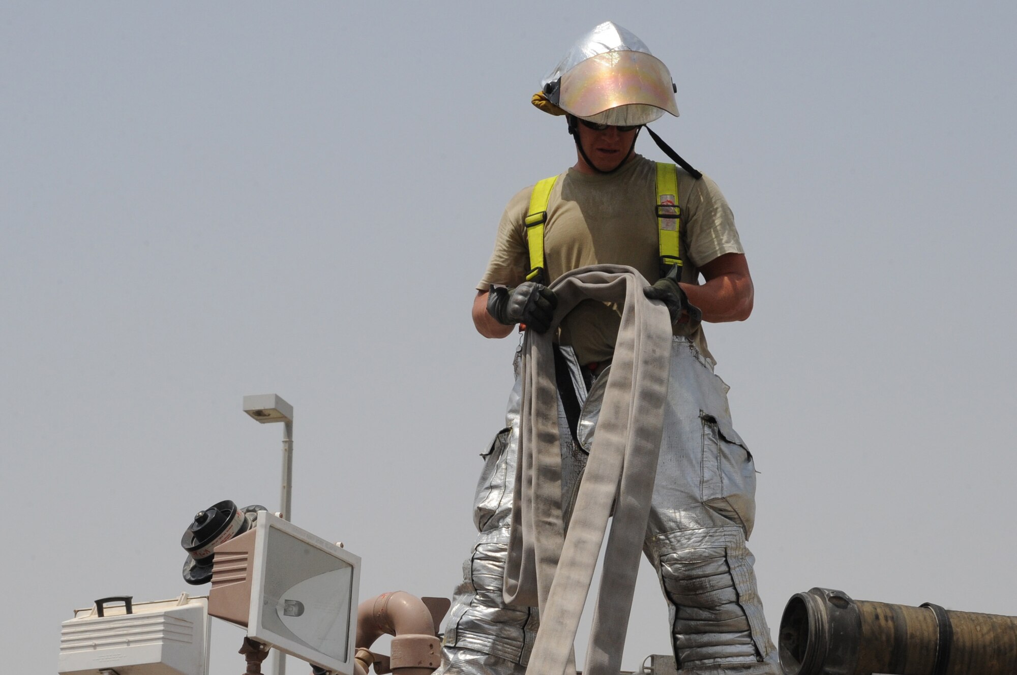 Airman 1st Class John McCurley, 380th Expeditionary Civil Engineer Squadron fire fighter, reels up a hose after fighting a fire June 30 at a non-disclosed base in Southwest Asia. The fire fighters’ quick response minimized damage to the building. (U.S. Air Force photo/Tech. Sgt. April Wickes)