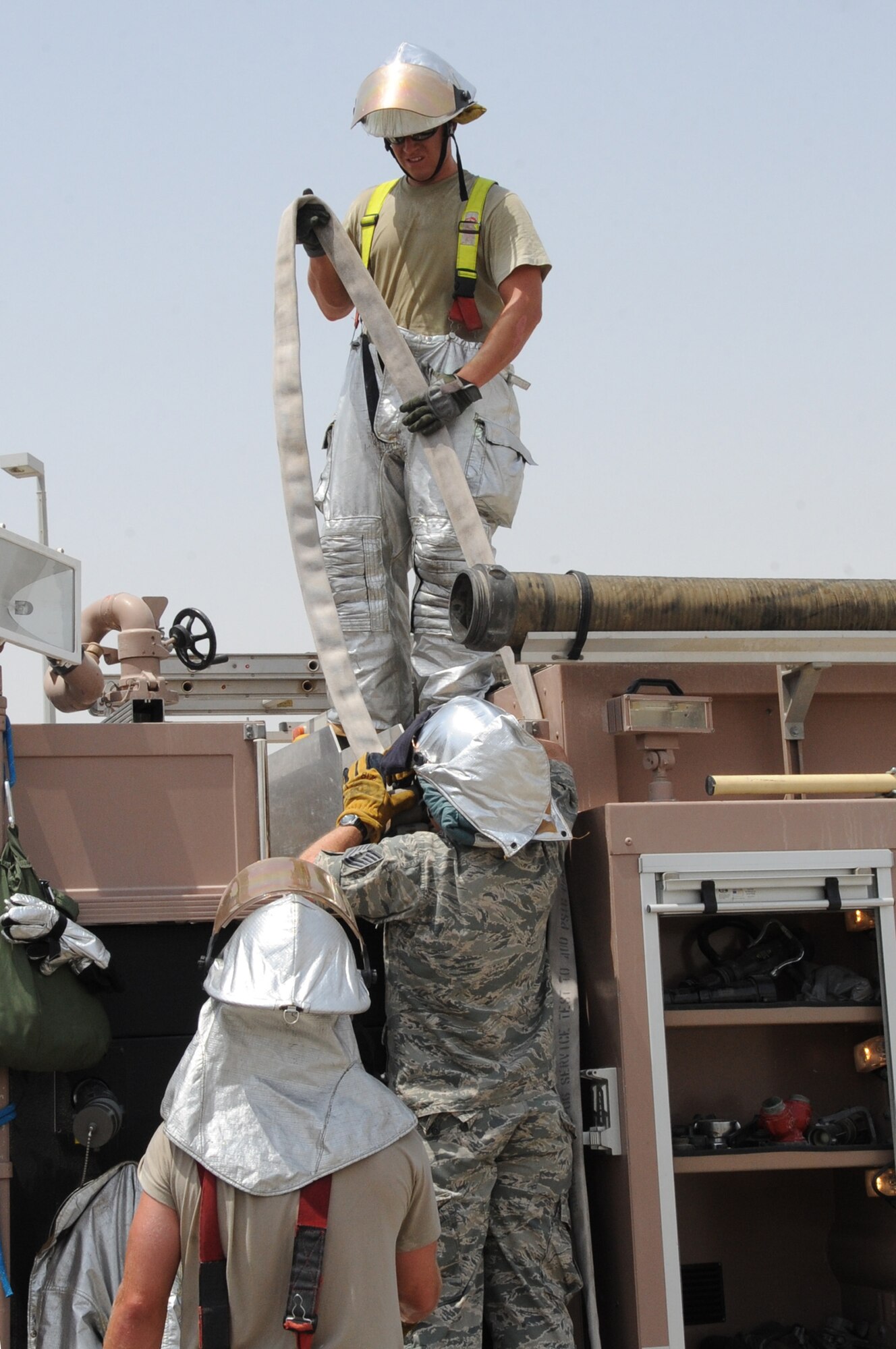 Fire fighter’s from the 380th Expeditionary Civil Engineer Squadron reel up a fire hose after fighting a fire June 30 at a non-disclosed base in Southwest Asia. The fire fighters’ quick response minimized damage to the building. (U.S. Air Force photo/Tech. Sgt. April Wickes) 
