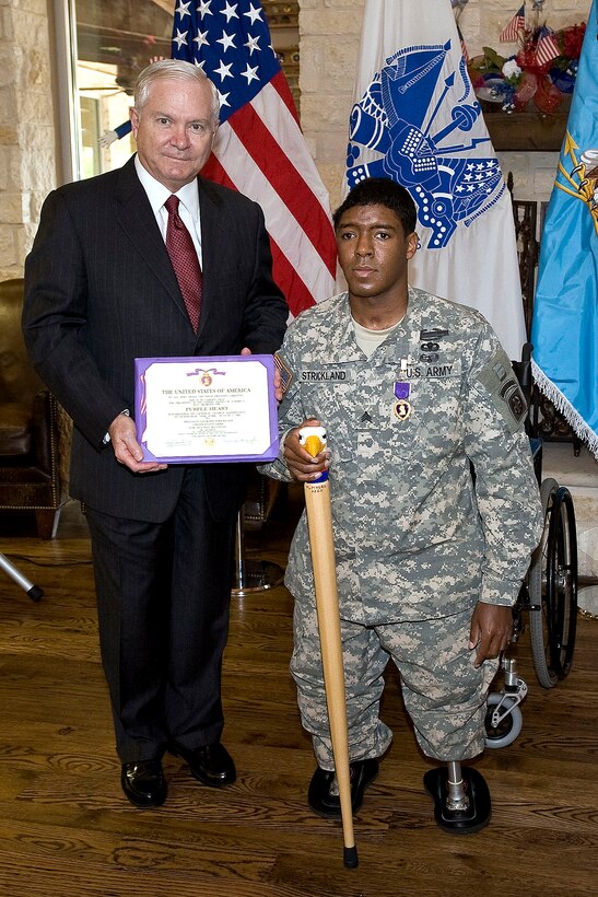 Defense Secretary Robert M. Gates awards the Purple Heart to Army Sgt. Legrand Strickland for wounds received in combat while deployed to Afghanistan at Brooke Army Medical Center, Texas, June 30, 2010.