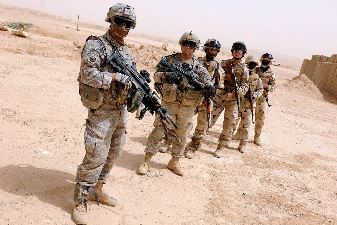U.S. Army Spc. Salah Al Hakim, front left, a waits along with other U.S. and Iraqi
Army soldiers to practice loading a mock UH-60 Black Hawk helicopter on Camp Kassum, Al Asad Air Base, Iraq, June 22, 2010. Hakim is assigned to the 82nd Airborne Division's Company B, 1st Battalion, 504th Parachute Infantry Regiment, 1st Advise and Assist Brigade.