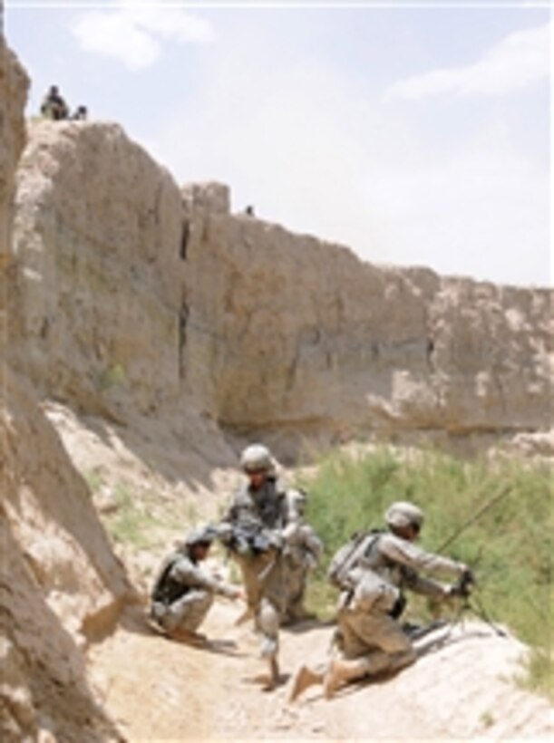 U.S. Army soldiers from White Tank, 2nd Platoon, Delta Company, 1st Battalion, 4th Infantry Regiment set up a tactical satellite system as Afghan soldiers watch from the high ground while on patrol in Zabul province, Afghanistan, on June 25, 2010.  