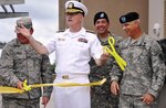 Medical Education and Training Campus commandant Rear Adm. William R. Kiser (center) celebrates cutting the ribbon opening the center along with Lt. Gen. (Dr.) Charles Green, U.S. Air Force Surgeon General (left) and AMEDD C&S commanding general and chief of  U.S. Army Medical Services Corps Maj. Gen. David A. Rubenstein (right). (U.S. Army photo by Steve Elliott)