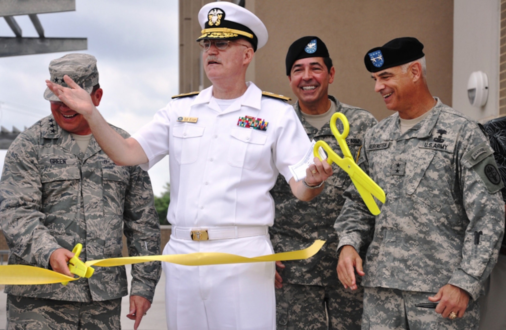 Medical Education and Training Campus commandant Rear Adm. William R. Kiser (center) celebrates cutting the ribbon opening the center along with Lt. Gen. (Dr.) Charles Green, U.S. Air Force Surgeon General (left) and AMEDD C&S commanding general and chief of  U.S. Army Medical Services Corps Maj. Gen. David A. Rubenstein (right). (U.S. Army photo by Steve Elliott)