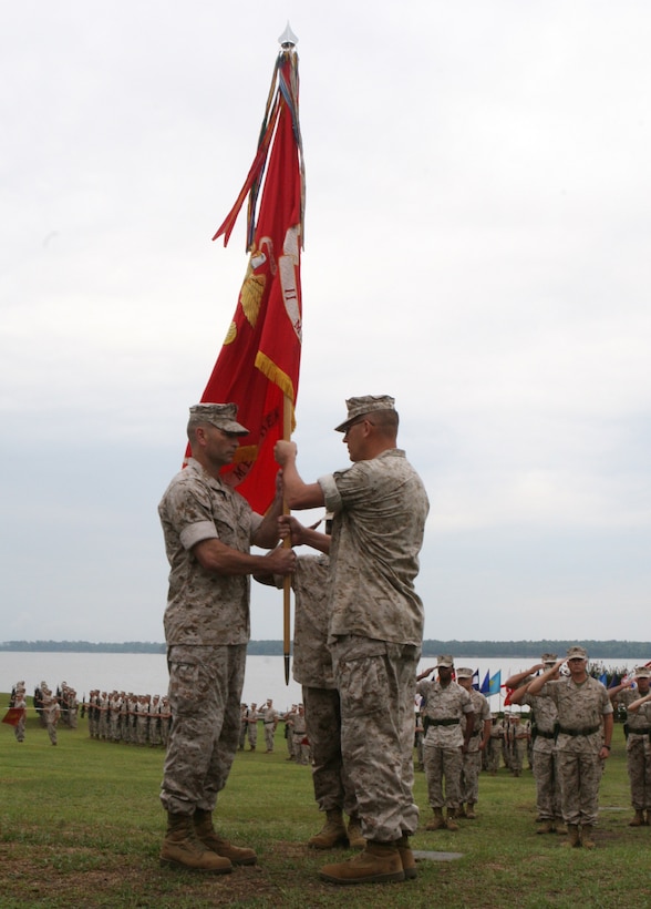 Col. Scott D. Aiken (right), former commanding officer of II Marine Expeditionary Force Headquarters Group, hands over the organizational battle color to the group’s incoming commanding officer, Col. Michael M. Sweeney during a change of command ceremony aboard Camp Lejeune, N.C., July 1. Aiken, who was in command of II MHG since 2008, will go on to become the II MEF operations officer.