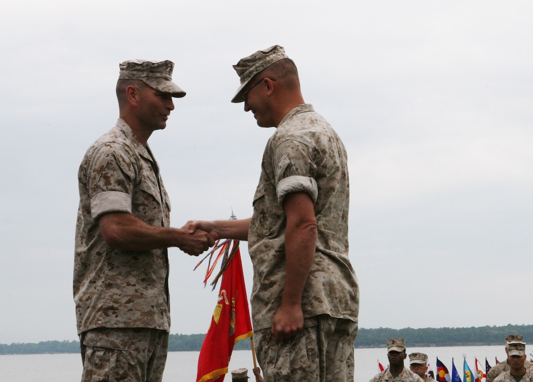 Col. Scott D. Aiken (right), former commanding officer of II Marine Expeditionary Force Headquarters Group, shakes hands with Col. Michael M. Sweeney, the incoming commanding officer of II MHG, during a change of command ceremony aboard Camp Lejeune, N.C., July 1.  Aiken will go on to be the II MEF operations officer.