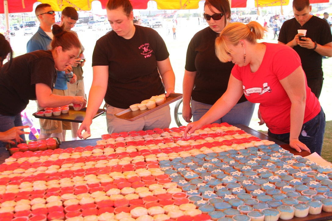 Family readiness volunteers create a cupcake flag at the 1st Battalion, 7th Marine Regiment, Family Day event at the Del Valle Sports Complex July 2. Katie Braus, a family readiness volunteer, baked 650 cupcakes to create the flag.