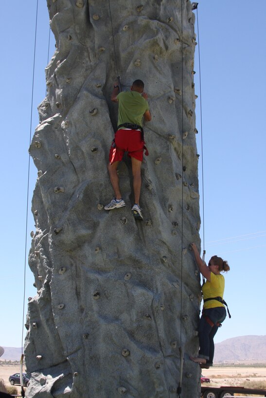 Marines and family Members scale the climbing wall during the 1st Battalion, 7th Marine Reigment, Family Day event at the Del Valle Sports Complex July 2. Many other activities were set up for the event, such as a dunk tank, water slide, trampoline and swings.