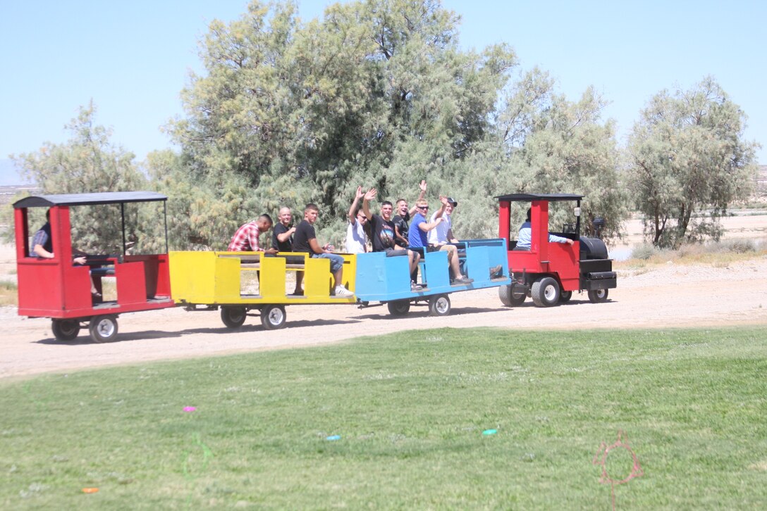 Marines and family members connect with their inner-children on a train ride which circled the Del Valle Sports Complex soccer field during 1st Battalion, 7th Marine Regiment's Family Day event at the soccer field by the physical fitness test course July 2.